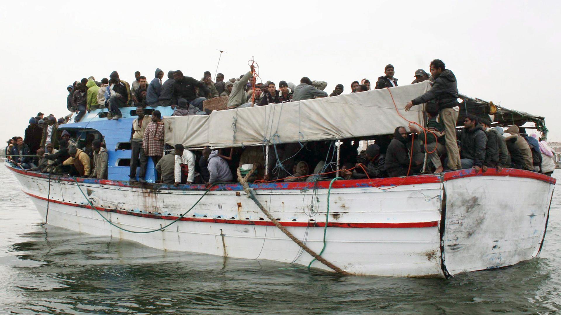 Überfülltes Boot mit afrikanischen Flüchtlingen vor der Küste Libyens