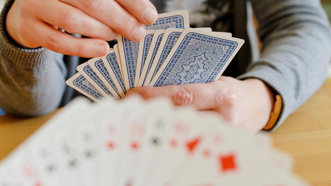 Detailaufnahmen von zwei Menschen beim Karten spielen.