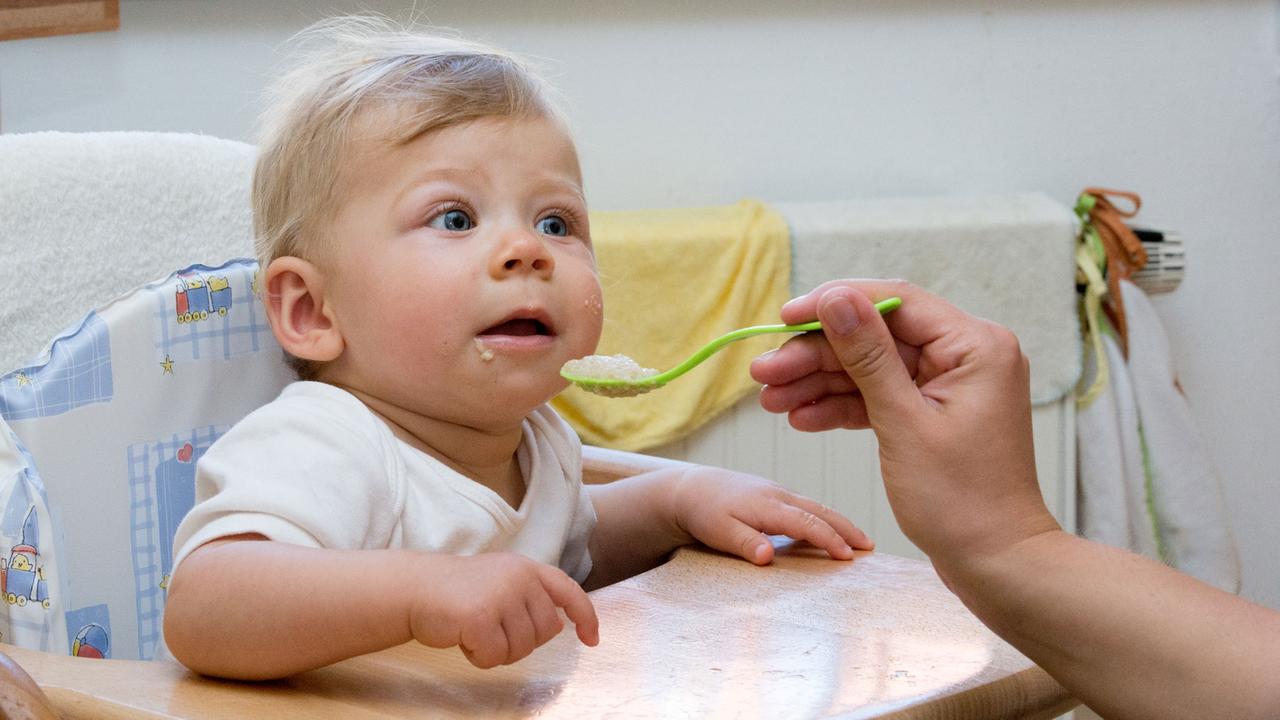 Ein Baby wird mit Brei gefüttert.