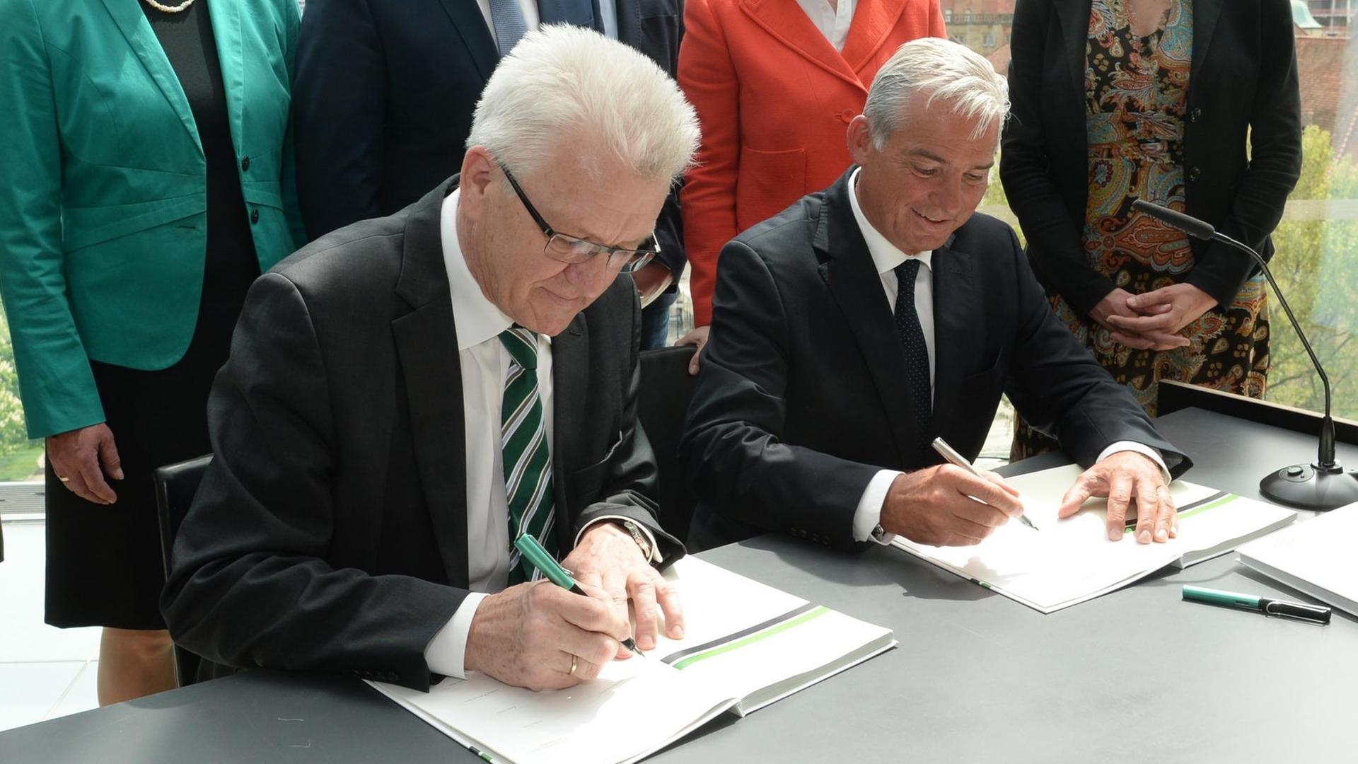 Der baden-württembergische Ministerpräsident Winfried Kretschmann (Bündnis 90/Die Grünen) und der baden-württembergische CDU-Vorsitzende Thomas Strobel (r.) unterschreiben am 09.05.2016 in Stuttgart den Koalitionsvertrag für die bundesweit erste grün-schwarze Landesregierung. Der baden-württembergische Ministerpräsident Winfried Kretschmann (Bündnis 90/Die Grünen) und der baden-württembergische CDU-Vorsitzende Thomas Strobel (r.) unterschreiben am 09.05.2016 in Stuttgart den Koalitionsvertrag für die bundesweit erste grün-schwarze Landesregierung.