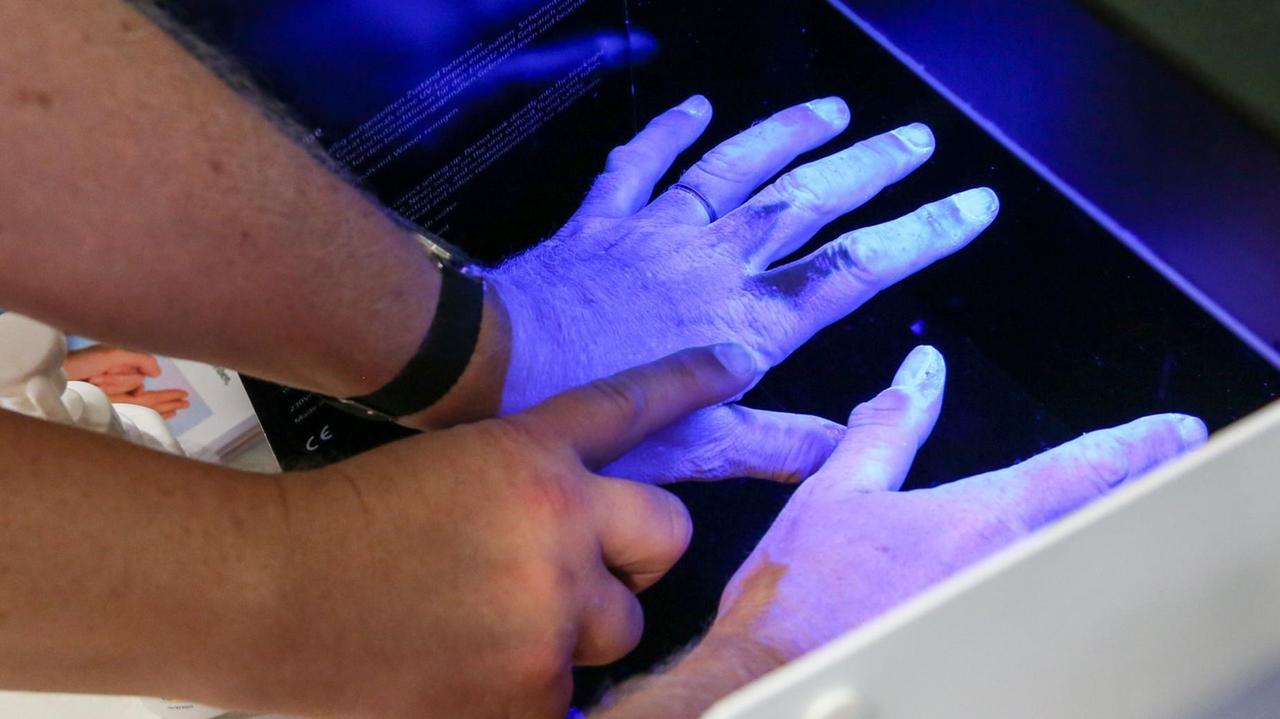 Klinikhygiene in einem Bonner Krankenhaus. UV-Licht macht Verschmutzungen an den Händen sichtbar. Klinikhygiene in einem Bonner Krankenhaus. UV-Licht macht Verschmutzungen an den Händen sichtbar.