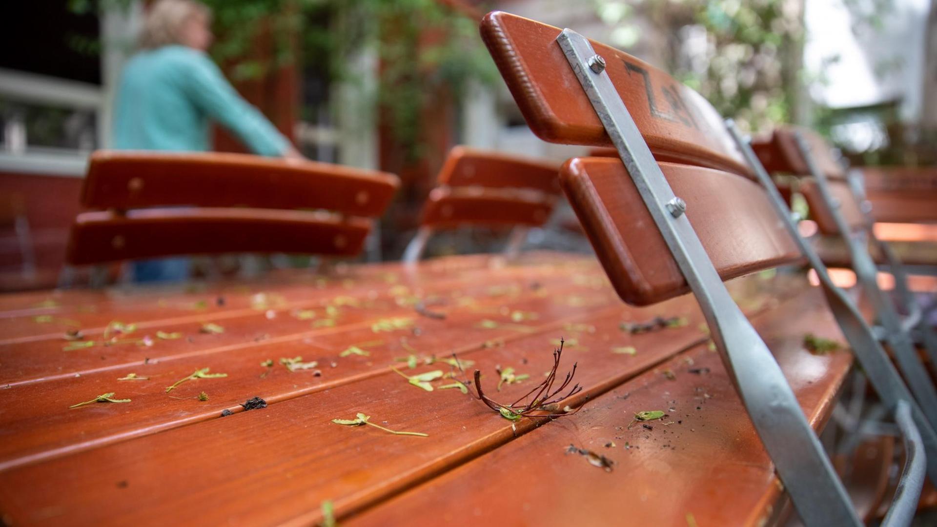 Stühle stehen in einem wegen des Coronavirus noch geschlossenen Biergarten an die Tische gelehnt. Stühle stehen in einem wegen des Coronavirus noch geschlossenen Biergarten an die Tische gelehnt.