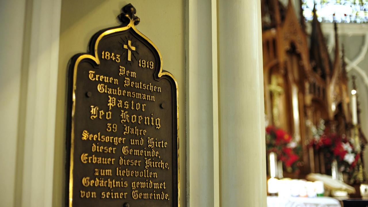 An einer Säule in der St. Pauls-Kirche erinnert eine Tafel mit goldenenen Lettern an den 1919 verstorbenen Pastor Leo Koenig, einen früheren Pfarrer der deutschsprachigen Gemeinde.