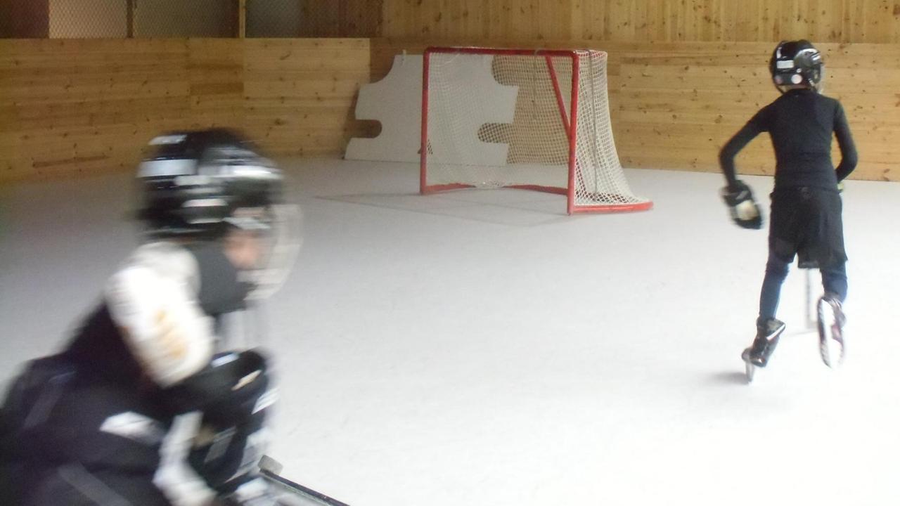 Zwei Kinder trainieren in einer Eishockey Halle auf Polyethylen-Boden mangels Eiszeiten. Zwei Kinder trainieren in einer Eishockey Halle auf Polyethylen-Boden mangels Eiszeiten.