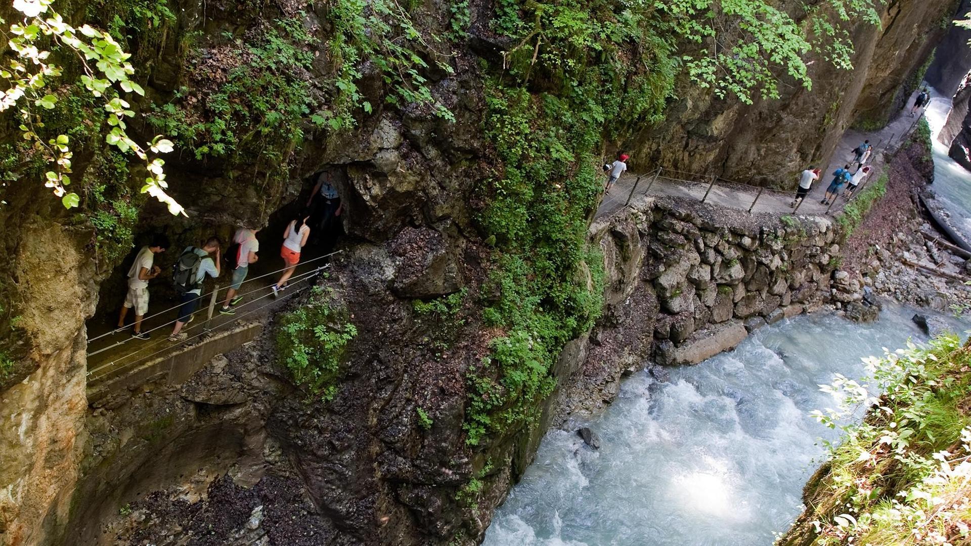 Wanderer gehen in Garmisch-Partenkirchen (Bayern) durch die Partnachklamm. Wanderer gehen in Garmisch-Partenkirchen (Bayern) durch die Partnachklamm.