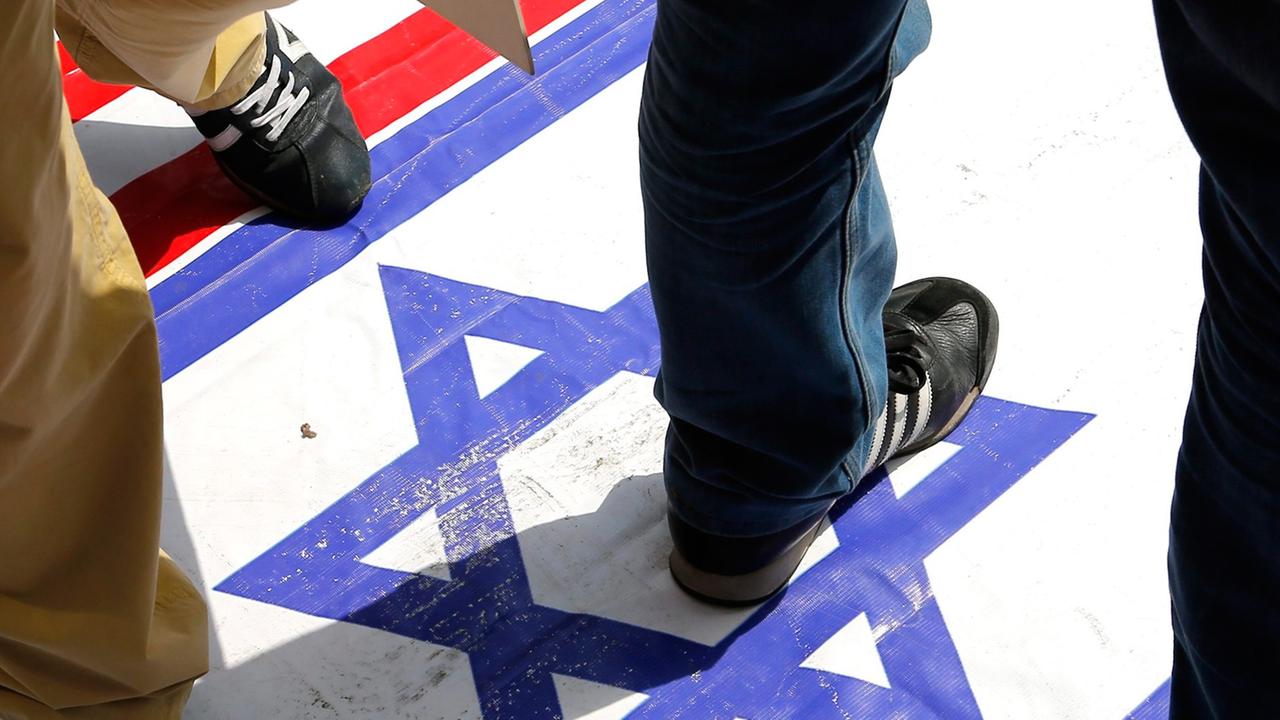 Türkische Demonstranten treten auf eine israelische Flagge bei dem Protest gegen die israelischen Angriffe auf Gaza nach dem Freitagsgebet in der Fatih Moschee in Istanbul am 25. Juli 2014. Türkische Demonstranten treten auf eine israelische Flagge bei dem Protest gegen die israelischen Angriffe auf Gaza nach dem Freitagsgebet in der Fatih Moschee in Istanbul am 25. Juli 2014.