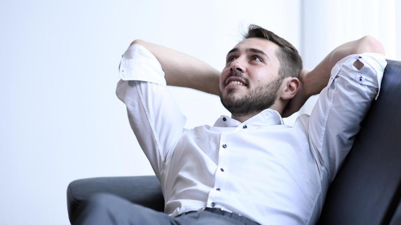 Bloch liegt schräg auf einem Sofa in seinem Büro und die Arme hinter dem Kopf verschränkt. Bloch liegt schräg auf einem Sofa in seinem Büro und die Arme hinter dem Kopf verschränkt.