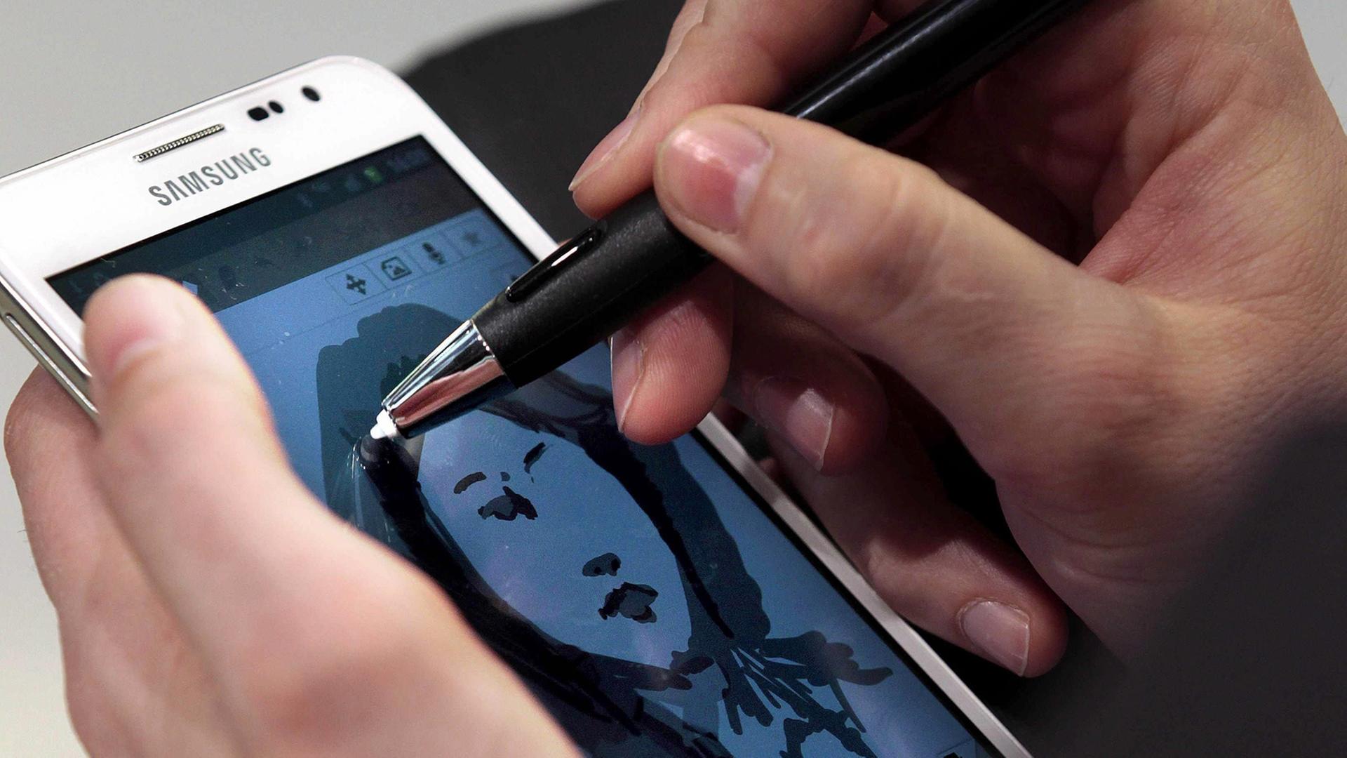 Ein Künstler malt ein Bild auf einem Samsung Galaxy Note Ein Künstler malt ein Bild auf einem Samsung Galaxy Note