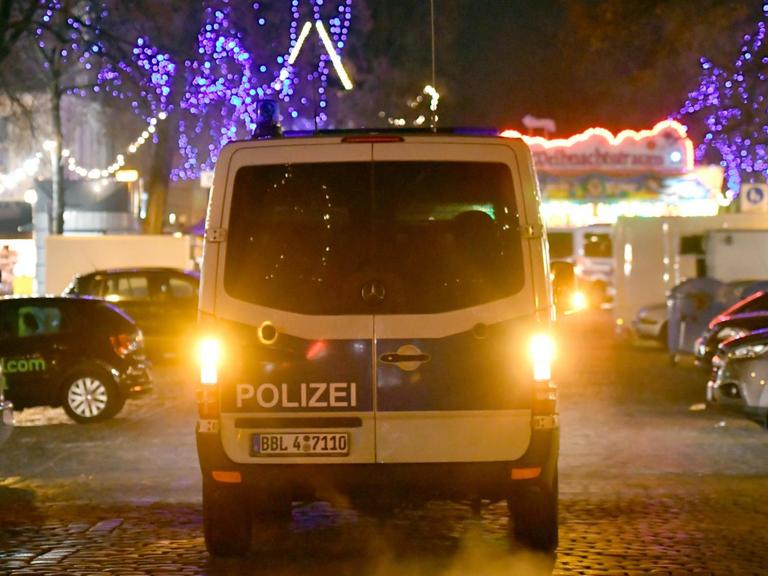 Ein Polizeifahrzeug fährt am 01.12.2017 auf einer Straße an einen Weihnachtsmarkt in der Innenstadt von Potsdam (Brandenburg). An dem Markt haben Bombenentschärfer am Freitag ein verdächtiges Paket unschädlich gemacht.