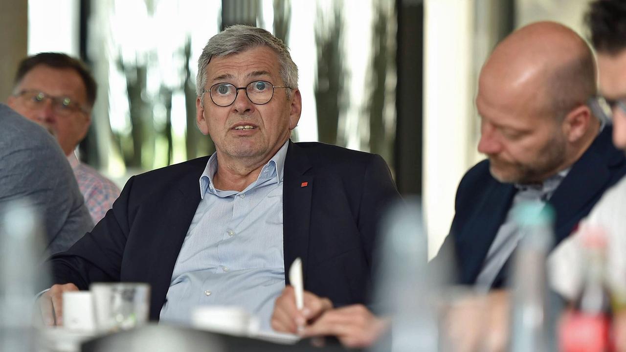 Jörg Hofmann, erster Vorsitzender der IG Metall, sitzt bei einer Betriebsbesichtigung im ZF-Werk in Saarbrücken an einem Tisch. Jörg Hofmann, erster Vorsitzender der IG Metall, sitzt bei einer Betriebsbesichtigung im ZF-Werk in Saarbrücken an einem Tisch.
