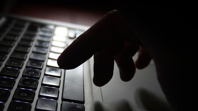 Ein Mann arbeitet an der Tastatur eines Laptops.