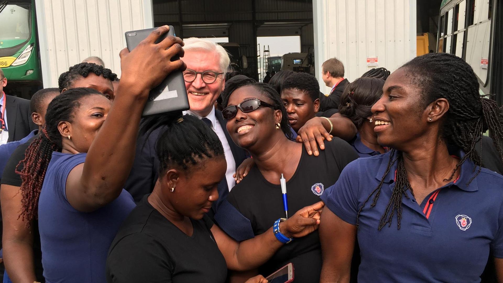 Bundespräsident Frank-Walter Steinmeier und Fahrschülerinnen, die eine Ausbildung als Busfahrerinnen in Accra machen.