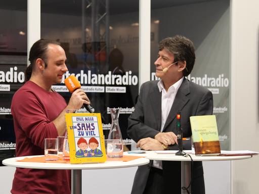 Jan Costin Wagner (l.) und Moderator Joachim Scholl am Deutschlandradio-Stand der Frankfurter Buchmesse 2015.