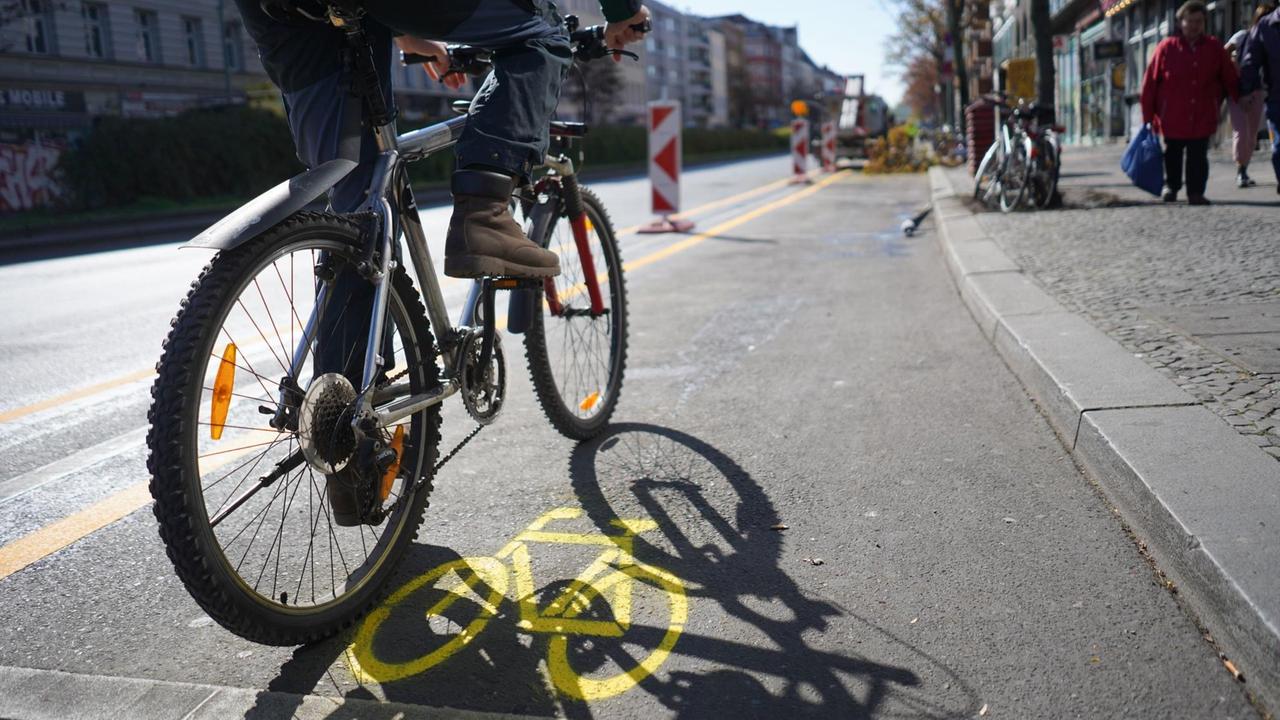 Ein Mann befährt mit seinem Fahrrad einen temporären Radverkehrsstreifen auf dem Kottbusser Damm in Berlin Ein Mann befährt mit seinem Fahrrad einen temporären Radverkehrsstreifen auf dem Kottbusser Damm in Berlin