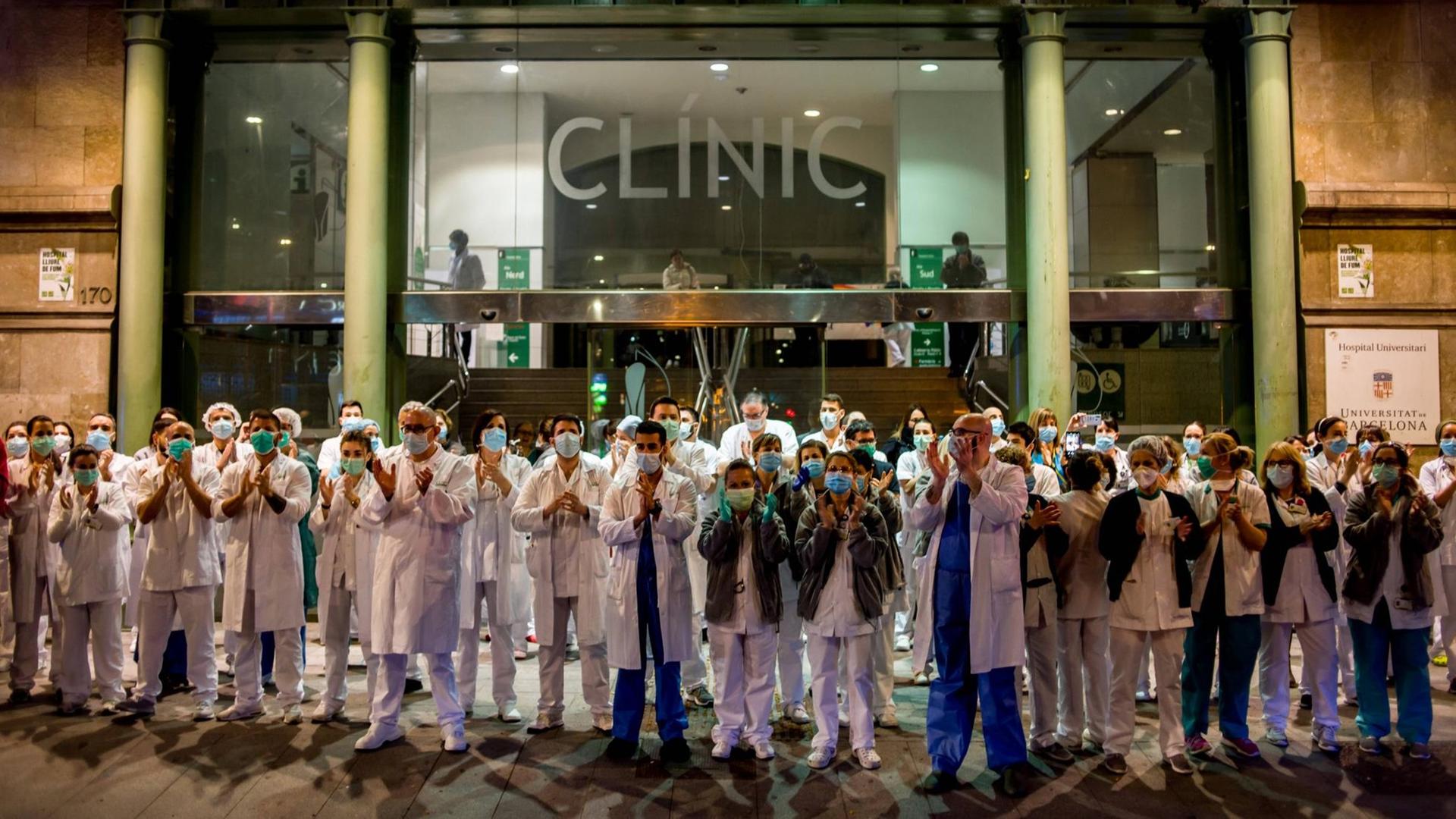 Pflegekräfte stehen am 25. März vor einem Krankenhaus in Barcelona und applaudieren. Pflegekräfte stehen am 25. März vor einem Krankenhaus in Barcelona und applaudieren.