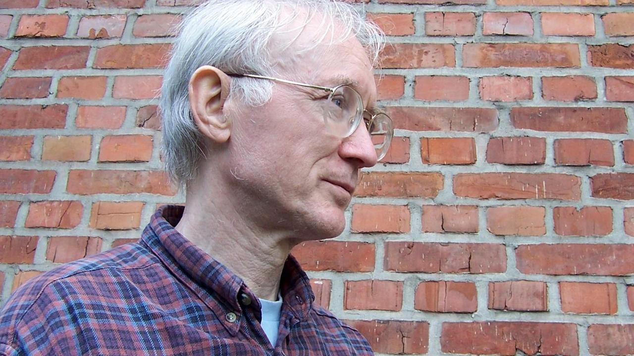 Porträt von Herbert Henck vor einer roten Ziegelsteinmauer. Porträt von Herbert Henck vor einer roten Ziegelsteinmauer.