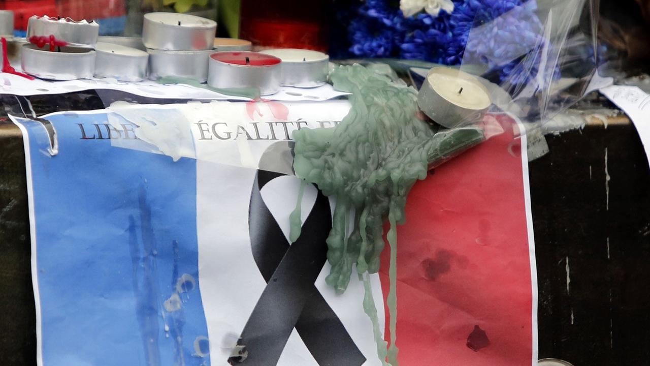 Nach den Attentaten vom November 2015 hängen Bilder und Fahnen auf dem Platz der Republik in Paris.