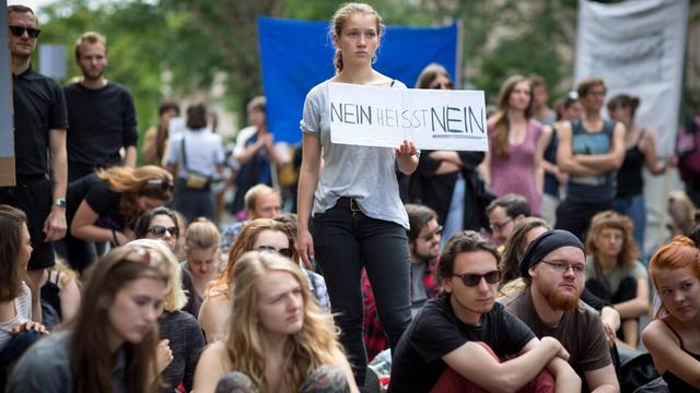 Eine Demo in Berlin, in der Mitte hält eine junge Frau ein Schild mit der Aufschrift "Nein heißt Nein" hoch.