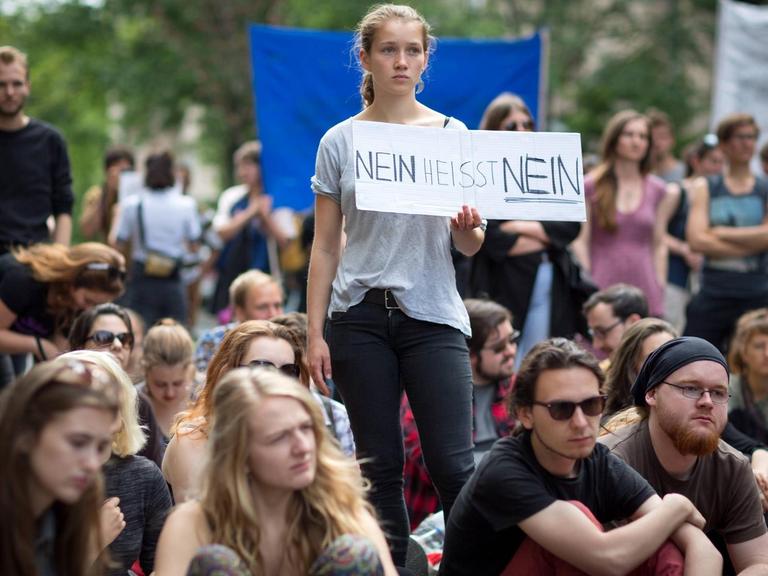 Eine Demo in Berlin, in der Mitte hält eine junge Frau ein Schild mit der Aufschrift "Nein heißt Nein" hoch.