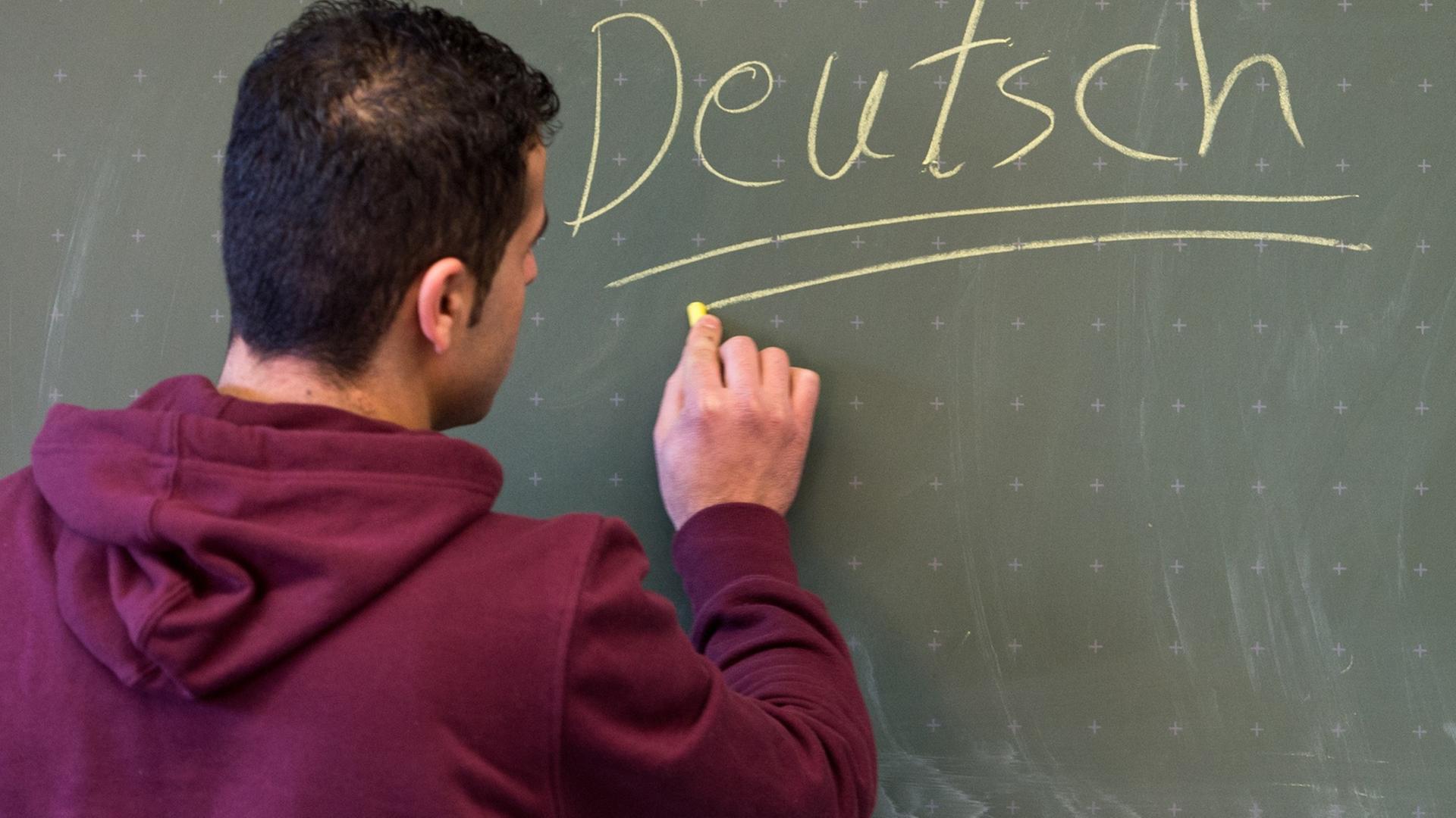 Ein Asylbewerber schreibt in einer Städtischen Berufsschule in Regensburg (Bayern) das Wort "Deutsch" an die Tafel. Ein Asylbewerber schreibt in einer Städtischen Berufsschule in Regensburg (Bayern) das Wort "Deutsch" an die Tafel.