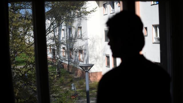 Ein Mann aus Afghanistan steht in Berlin am Fenster in seiner Unterkunft.