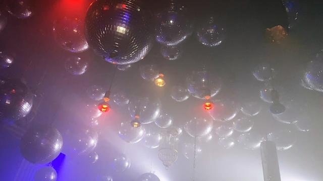 Viele Discokugeln im künstlichen Nebel, hängen an der Decke des Berliner Clubs Wilde Renate.