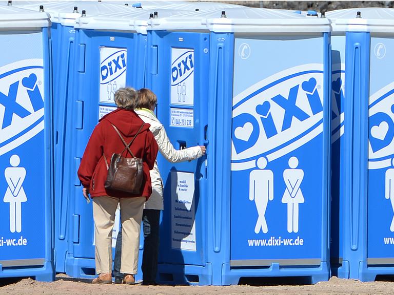 Zwei Frauen stehen vor Dixi-Klos, aufgenommen 2013 in Hamburg