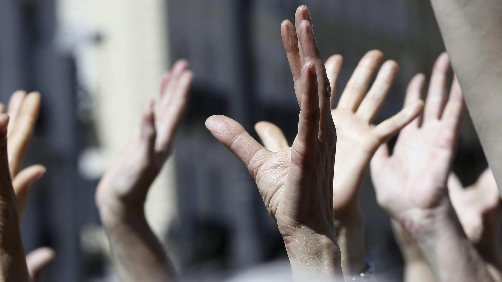 Demonstranten der spanischen 15-M Bewegung heben ihre Hände in die Luft. Demonstranten der spanischen 15-M Bewegung heben ihre Hände in die Luft.