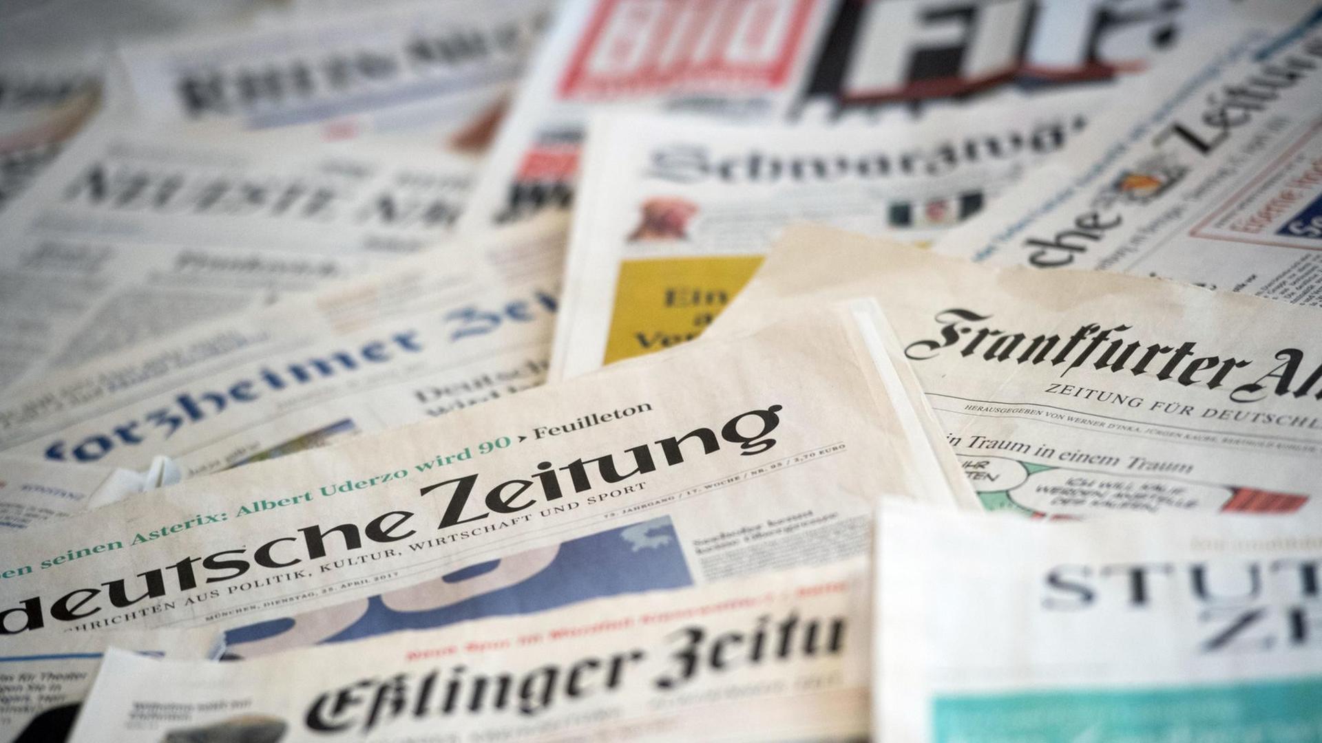 Mehrere Tageszeitungen liegen verstreut auf einem Tisch. Zu sehen sind u.a. die Eßlinger Zeitung, die Süddeutsche Zeitung und die Frankfurter Allgemeine Zeitung.