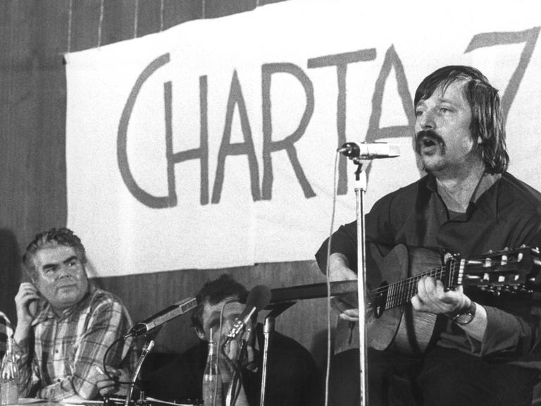 Der aus der DDR ausgebürgerte Liedermacher Wolf Biermann (r.) tritt am 27.03.77 im Saal des Frankfurter Gewerkschaftshauses in einer Solidaritätsveranstaltung für die Bürgerrechtsbewegung in der CSSR "Charta 77" auf. Auf dem Podium v.l. Studentenführer Rudi Dutschke, Jiri Pelikan (ehemaliger Direktor des Prager Rundfunks) und Adam Michnik (ehemaliger polnischer Studentensprecher).