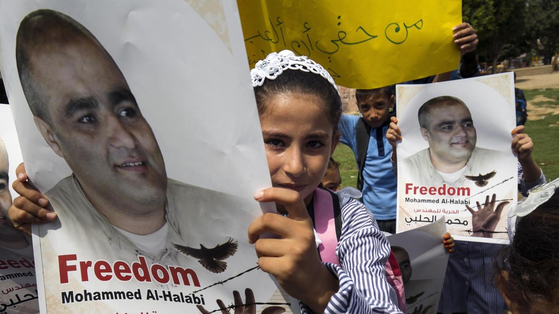 Palästinensische Kinder mit Plakaten, auf denen steht: "Freiheit für Mohammed al-Halabi". Palästinensische Kinder mit Plakaten, auf denen steht: "Freiheit für Mohammed al-Halabi".