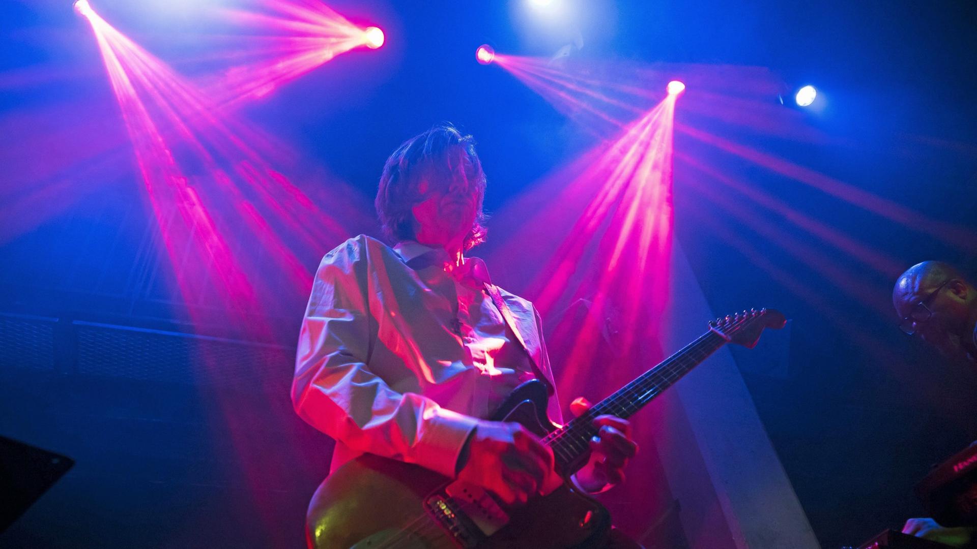 Thurston Moore steht in London mit Gitarre auf der Bühne. Thurston Moore steht in London mit Gitarre auf der Bühne.