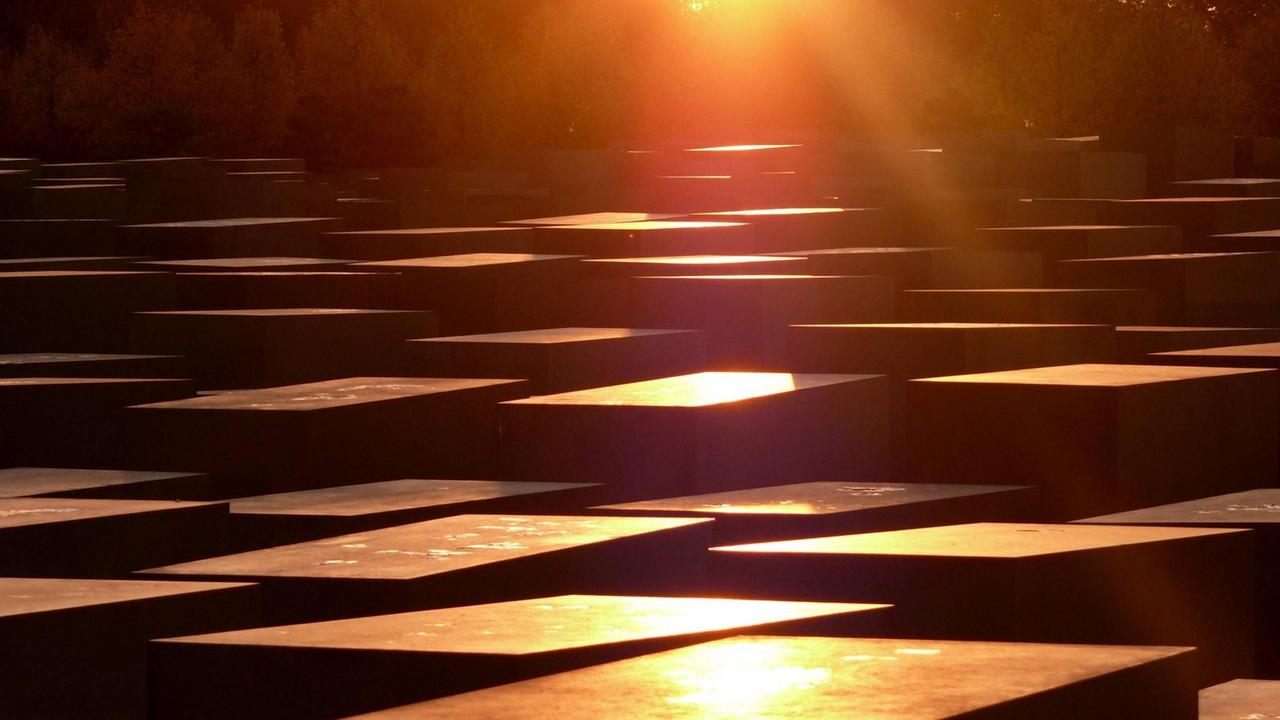 Blick auf die Blöcke des Holocoustdenkmales in Berlin bei gleißendem, orangefarbenem Licht. Blick auf die Blöcke des Holocoustdenkmales in Berlin bei gleißendem, orangefarbenem Licht.