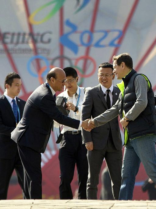 Alexander Zhukov (3.v.r.), Leiter der International Olympic Committee's Evaluation Commission, schüttelt einem Mitglied des Komitees der Olympischen Spiele 2022 in Peking die Hände vor dem National Aquatics Center.
