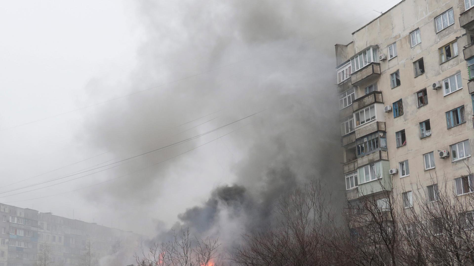 Flammen und Rauch kommen aus einem Haus in Mariupol. Ein ganzes Wohnviertel wurde beschossen. Flammen und Rauch kommen aus einem Haus in Mariupol. Ein ganzes Wohnviertel wurde beschossen.