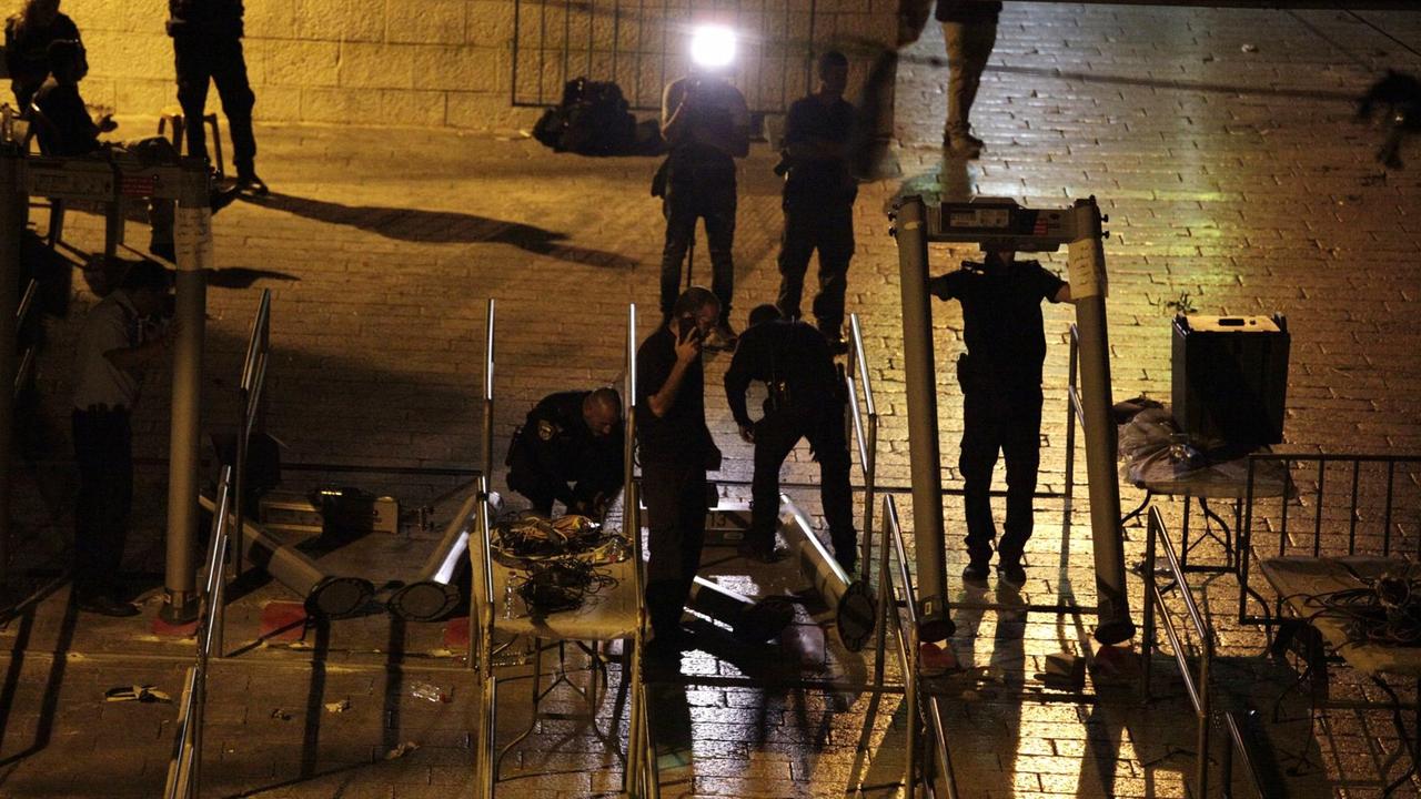 Polizisten montieren die Metalldetektoren am Tempelberg  in der Nacht ab