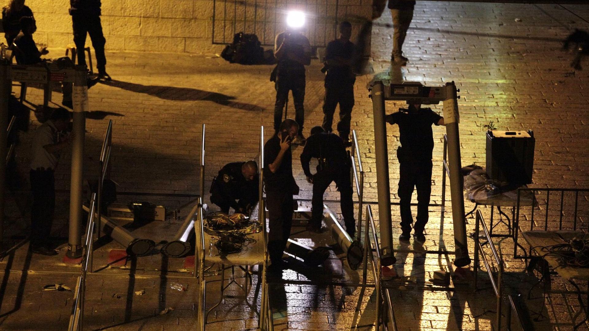 Israelische Polizisten montieren die umstrittenen Metalldetektoren am Tempelberg in Jerusalem ab Israelische Polizisten montieren die umstrittenen Metalldetektoren am Tempelberg in Jerusalem ab