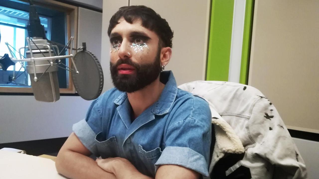Der Künstler Tom Neuwirth - auch Conchita oder WURST – sitzt im kurzärmligen Jeanshemd und bunter Glitzerschminke unter den Augen vor dem Mikrofon im Studio von Deutschlandfunk Kultur. Der Künstler Tom Neuwirth - auch Conchita oder WURST – sitzt im kurzärmligen Jeanshemd und bunter Glitzerschminke unter den Augen vor dem Mikrofon im Studio von Deutschlandfunk Kultur.
