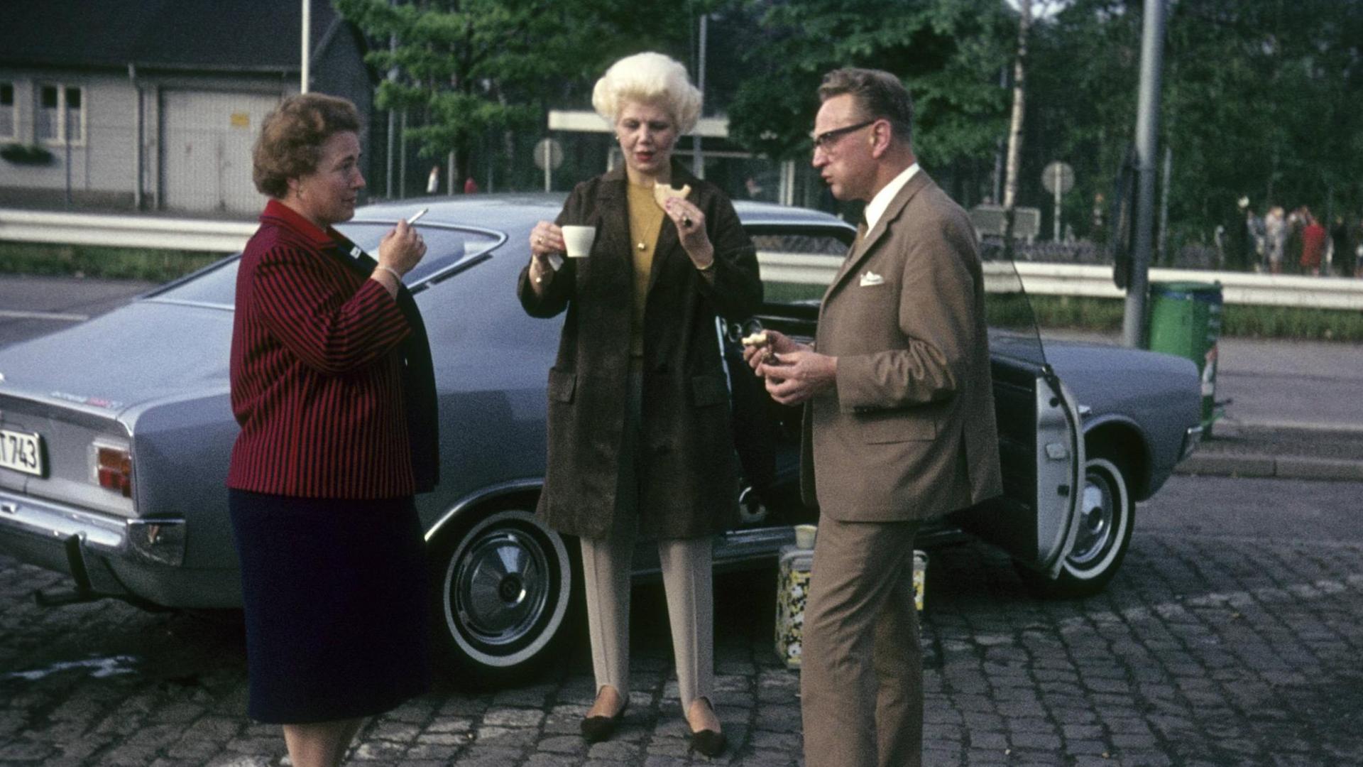 Frühstückpause für Autoreisende vor ihren Fahrzeugen an der Raststätte Helmstedt in den 1960er Jahren. Frühstückpause für Autoreisende vor ihren Fahrzeugen an der Raststätte Helmstedt in den 1960er Jahren.