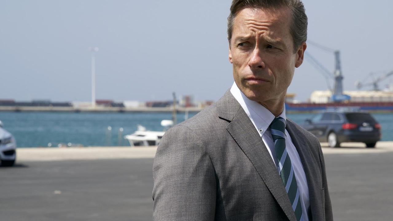 Guy Pearce steht mit ernster Miene auf einem Hafengelände Guy Pearce steht mit ernster Miene auf einem Hafengelände