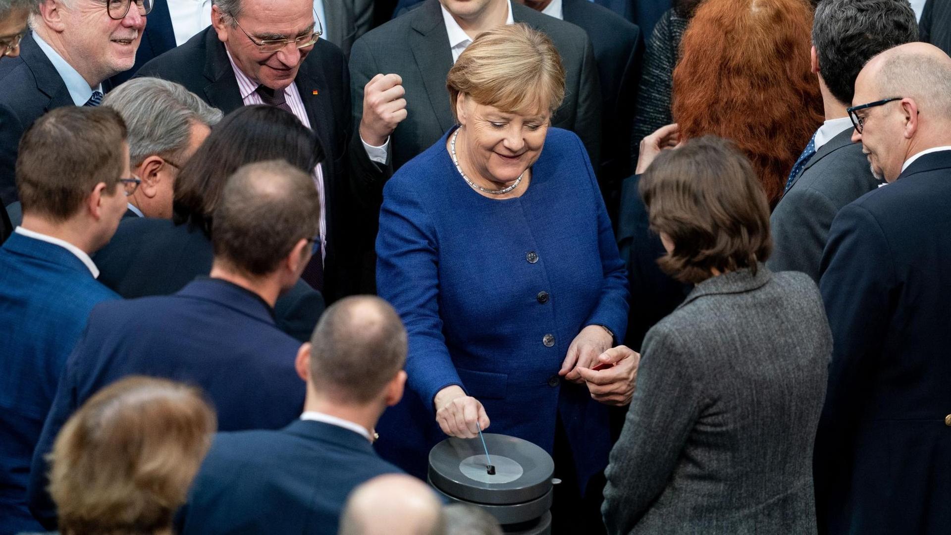 Bundeskanzlerin Angela Merkel (CDU, M) gibt bei der Sitzung des Bundestages ihre Stimmkarte bei der namentlichen Abstimmung über neue Organspende-Regeln ab. Bundeskanzlerin Angela Merkel (CDU, M) gibt bei der Sitzung des Bundestages ihre Stimmkarte bei der namentlichen Abstimmung über neue Organspende-Regeln ab.