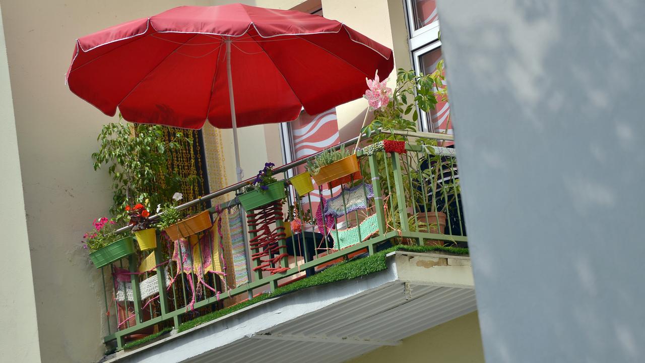 Ein roter Sonnenschirm ist in Berlin auf einem Balkon zu sehen. Ein roter Sonnenschirm ist in Berlin auf einem Balkon zu sehen.
