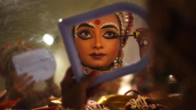 Eine Künstlerin, die Sita spielt, schminkt sich und bereitet sich auf eine Aufführung in Deu Delhi vor.