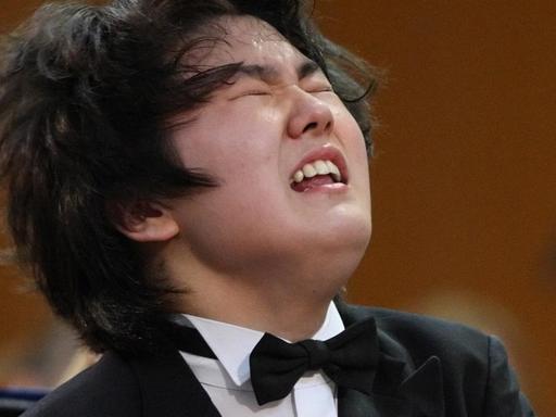 Seong Jin Cho sitzt mit angestrengt verzerrtem Gesichtsausdruck am Klavier.
