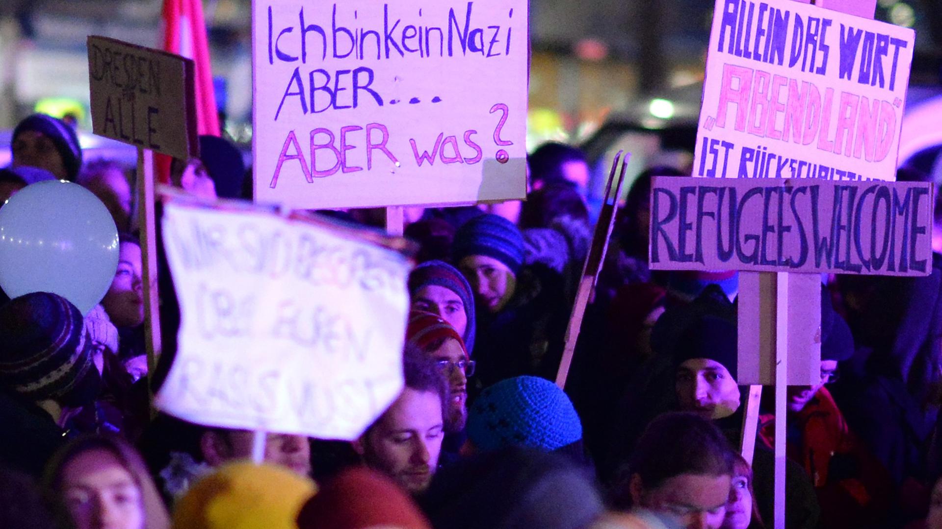 Demonstranten der Gegendemonstration zur "Pegida"-Kundgebung halten in Dresden Plakate hoch. Demonstranten der Gegendemonstration zur "Pegida"-Kundgebung halten in Dresden Plakate hoch.