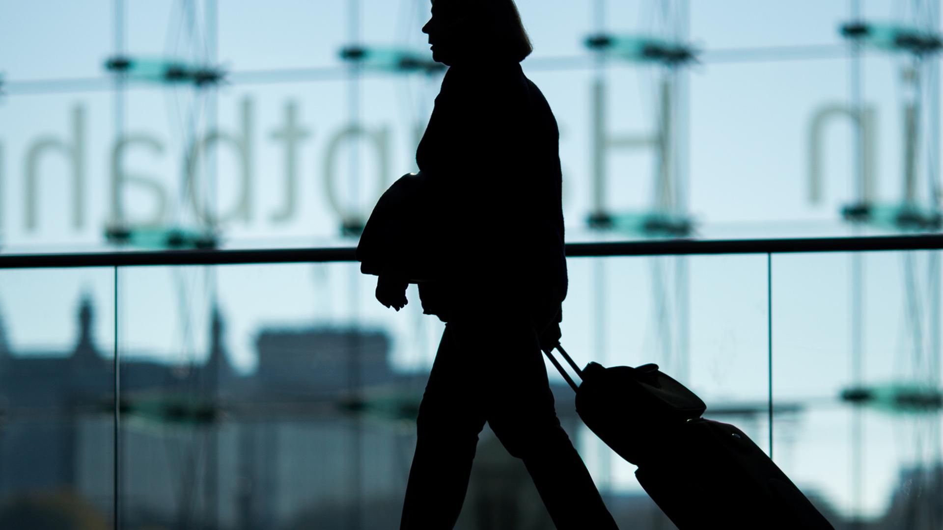 Eine Frau mit Koffer geht durch den Hauptbahnhof in Berlin. Eine Frau mit Koffer geht durch den Hauptbahnhof in Berlin.
