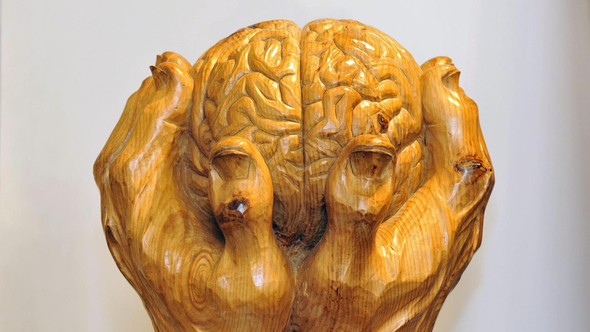 Zu sehen ist eine Skulptur des Künstlers Loris Marazzi. Zwei Hände halten ein Gehirn. Zu sehen ist eine Skulptur des Künstlers Loris Marazzi. Zwei Hände halten ein Gehirn.