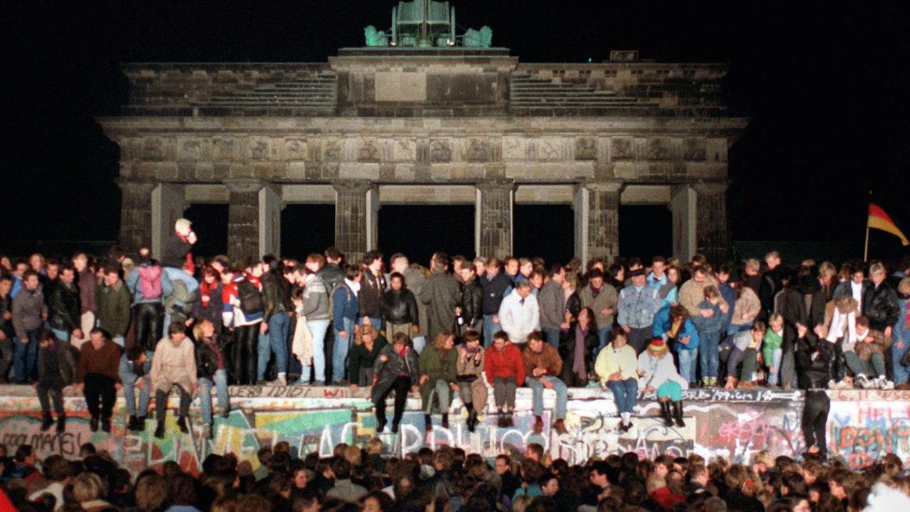 Jubelnde Menschen auf der Berliner Mauer am Brandenburger Tor am 10.11.1989. Am Abend des 09.11.1989 teilte SED-Politbüro Mitglied Günter Schabowski mit, daß alle DDR-Grenzen in die Bundesrepublik und nach West-Berlin für DDR-Bürger geöffnet werden. Jubelnde Menschen auf der Berliner Mauer am Brandenburger Tor am 10.11.1989. Am Abend des 09.11.1989 teilte SED-Politbüro Mitglied Günter Schabowski mit, daß alle DDR-Grenzen in die Bundesrepublik und nach West-Berlin für DDR-Bürger geöffnet werden.
