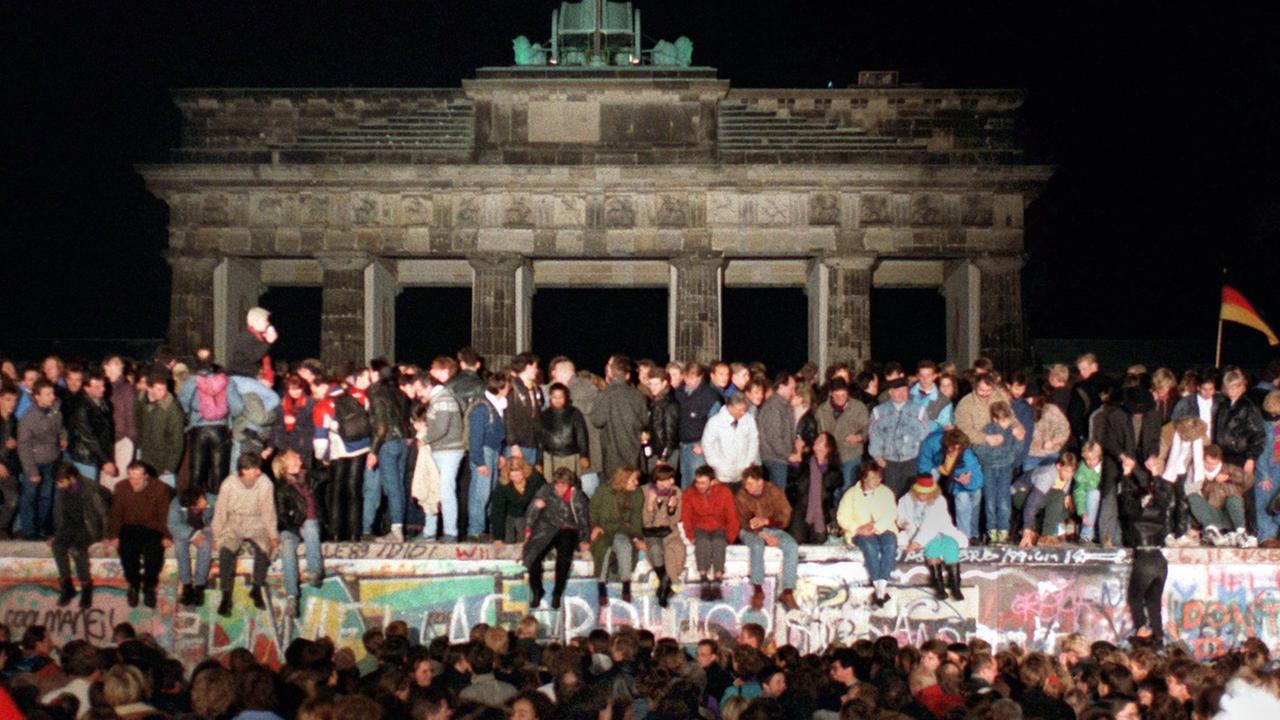 Jubelnde Menschen auf der Berliner Mauer am Brandenburger Tor am 10.11.1989. Am Abend des 09.11.1989 teilte SED-Politbüro Mitglied Günter Schabowski mit, daß alle DDR-Grenzen in die Bundesrepublik und nach West-Berlin für DDR-Bürger geöffnet werden. Jubelnde Menschen auf der Berliner Mauer am Brandenburger Tor am 10.11.1989. Am Abend des 09.11.1989 teilte SED-Politbüro Mitglied Günter Schabowski mit, daß alle DDR-Grenzen in die Bundesrepublik und nach West-Berlin für DDR-Bürger geöffnet werden.