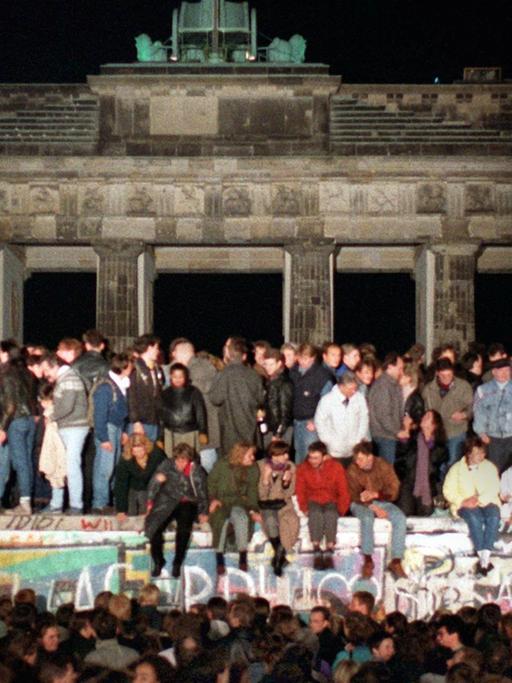 Jubelnde Menschen auf der Berliner Mauer am Brandenburger Tor am 10.11.1989. Am Abend des 09.11.1989 teilte SED-Politbüro Mitglied Günter Schabowski mit, daß alle DDR-Grenzen in die Bundesrepublik und nach West-Berlin für DDR-Bürger geöffnet werden.